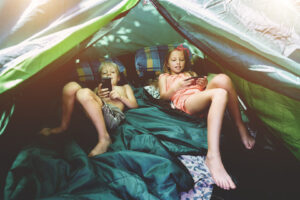 Boy and girl in a tent with mobile phones - Tinn Energi & Fiber - Tinn Energi & Fiber Barn som ser på mobil i teltet