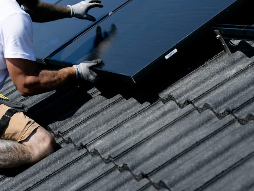 a man installing solar panels on a roof
