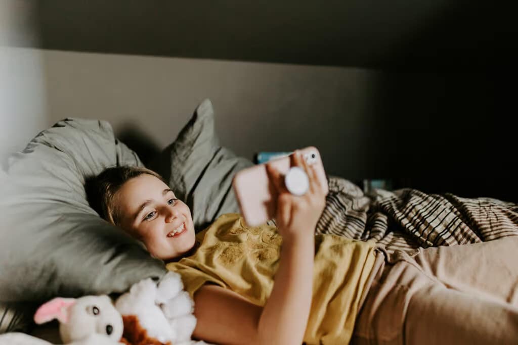 a girl lying on a bed taking a selfie