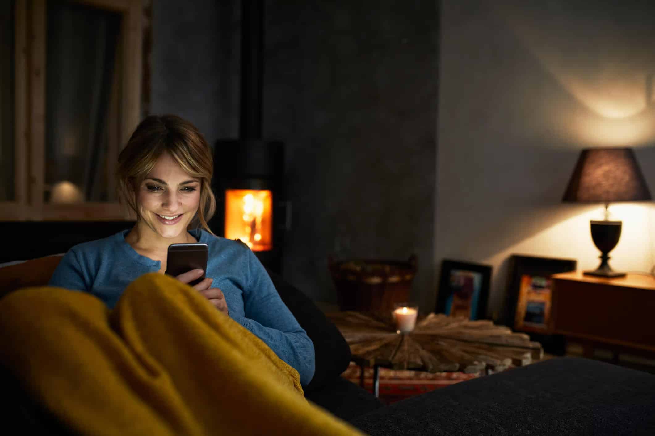 a woman sitting on a couch looking at her phone