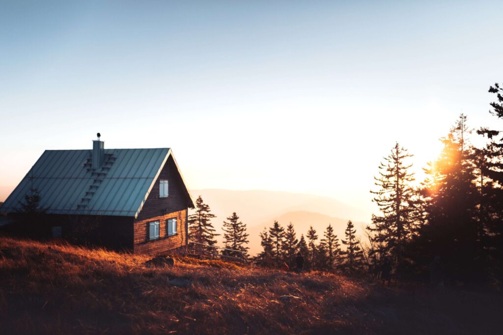 a house on a hill with trees in the background